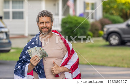 Hispanic man and USA flag. Paying tax in America. Value added tax. Taxation system. Patriotic man. Man with American flag and dollar money. Inflation concept. American tax policy. Advertisement 128389227