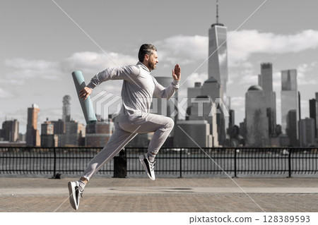 Man in sports suit training jogging. Running man in Manhattan. Morning sport workout jogger run in New York. Jogger run at sport training. Sportsman jogger running or jogging. Personal achievement 128389593