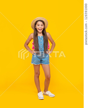 amazed teen kid in straw hat standing on yellow background 128391000