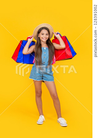 happy teen child with paper bags on yellow background. full length happy teen child with paper bags on yellow background. full length 128391002