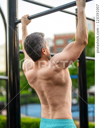 Sport and healthy. Muscular biceps and triceps. Strong athlete. Man pullup. Muscular man sportsman with strong back muscle. Sport pullup workout. Sport training. Man sportsman do pulling exercise Sport and healthy. Muscular biceps and triceps. Strong athlete. Man pullup. Muscular man sportsman with strong back muscle. Sport pullup workout. Sport training. Man sportsman do pulling exercise 128391007