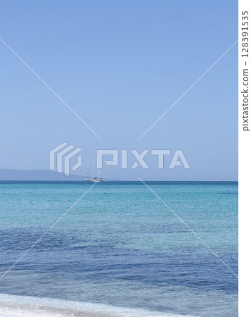 A serene image of a sailing yacht on a calm sea with a clear blue sky. The peaceful setting highlights the tranquility of the ocean, perfect for promoting relaxation and adventure. Sardinia A serene image of a sailing yacht on a calm sea with a clear blue sky. The peaceful setting highlights the tranquility of the ocean, perfect for promoting relaxation and adventure. Sardinia 128391535