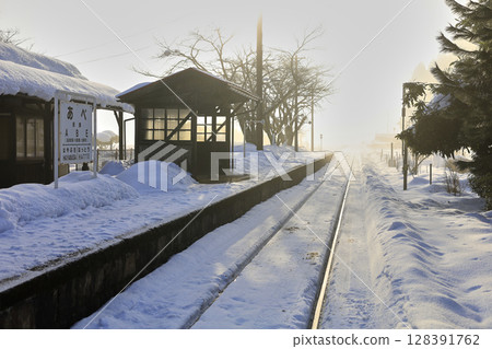 Local train tracks running through the snow on a winter morning Local train tracks running through the snow on a winter morning 128391762