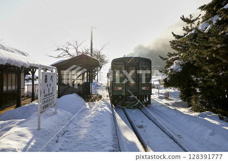A local train running through the snowy scenery of a winter morning 128391777