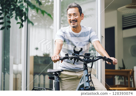 A middle-aged man in his 50s going out by bicycle 128393074