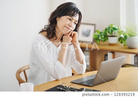 Middle woman worried while looking at a computer 128393219