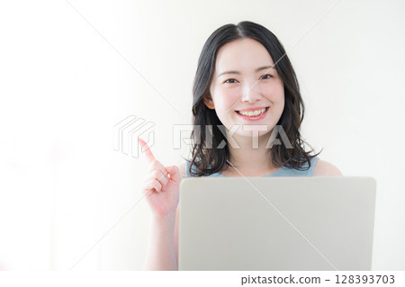 一位女士站在電腦前，用手指指著 128393703