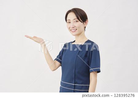 白色背景下手掌指向左側的女美容護士 128395276