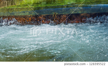 An image of a crystal clear stream bathed in the rays of summer light (Kumamoto Prefecture, Kuma District) 128395522