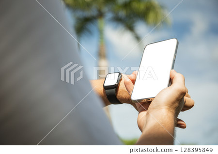 User uses a smartphone and smartwatch outdoors User uses a smartphone and smartwatch outdoors 128395849