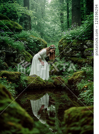 A fantastical figure of a woman in a white dress peering into a forest spring 128396294