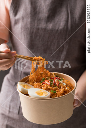 Spicy korean dried instant noodles with boiled egg, scallion, sesame seed and chili  128398321