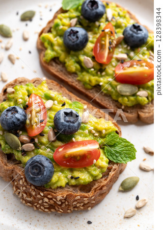 Avocado toast with blueberries, cherry tomatoes, sunflower seeds, pumpkin seeds and sesame seeds Avocado toast with blueberries, cherry tomatoes, sunflower seeds, pumpkin seeds and sesame seeds 128398344