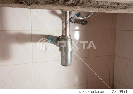 There is leak in water pipe under the sink, drain is clogged. Water Leak around pipe because sink is draining slowly and splashing in house home, high speed shutter freeze motion photo There is leak in water pipe under the sink, drain is clogged. Water Leak around pipe because sink is draining slowly and splashing in house home, high speed shutter freeze motion photo 128399513