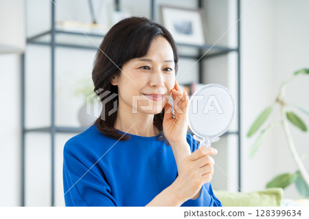 Middle-aged woman's beauty looking in the mirror 128399634