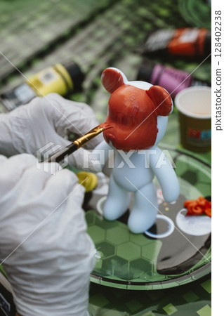 Painting a Toy Figure with Bright Colors 128402238