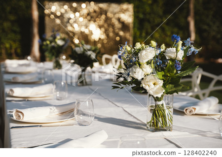 Elegant Outdoor Table Setting with Floral Arrangements 128402240