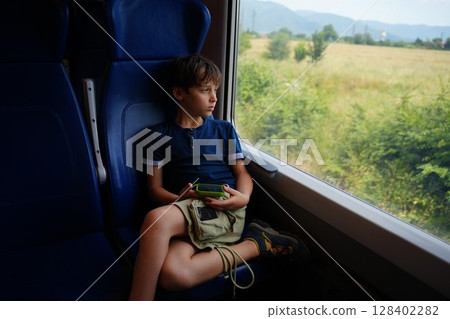 Child Gazing Out Train Window Holding Device 128402282