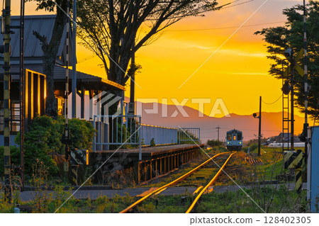 A scene of a station and a train shining in the light of the sunset (Miharashidai Station) (Minamiaso Village) 128402305
