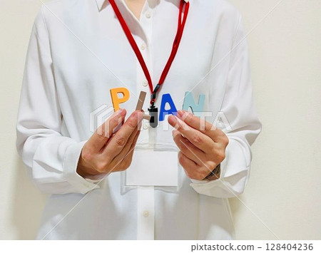 一名女員工手持「PLAN」字樣 一名女員工手持「PLAN」字樣 128404236