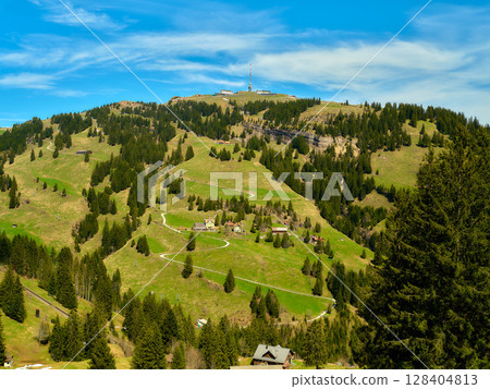 Scenic view of rolling hills and lush greenery in a mountainous region with clear skies Scenic view of rolling hills and lush greenery in a mountainous region with clear skies 128404813