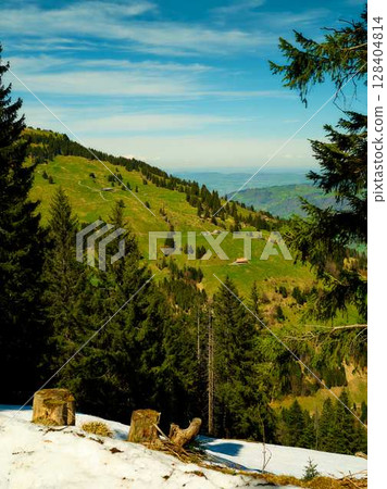 Stunning view of green hills and snow in a mountain landscape during a sunny day Stunning view of green hills and snow in a mountain landscape during a sunny day 128404814