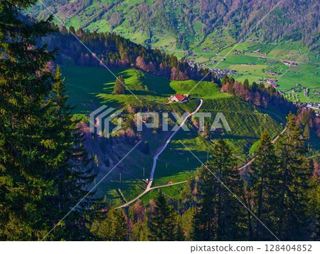 Stunning view of lush green hills and winding paths in a peaceful rural landscape during daytime Stunning view of lush green hills and winding paths in a peaceful rural landscape during daytime 128404852