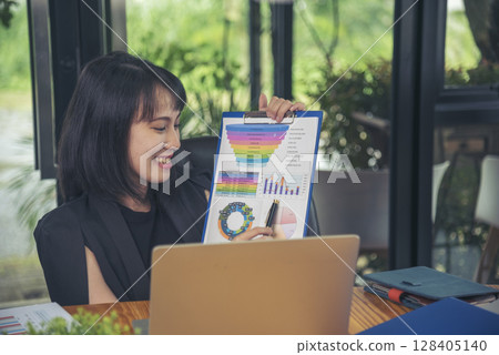 Business woman using smartphone, laptop on office desk. Female freelance reading financial graph charts Planning analyzing marketing data. Hands of young woman working in office firm business info. Business woman using smartphone, laptop on office desk. Female freelance reading financial graph charts Planning analyzing marketing data. Hands of young woman working in office firm business info. 128405140