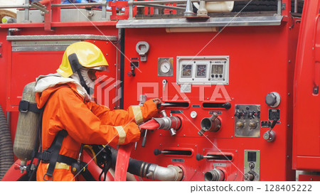 Fireman prepare equipment fighting extinguisher at fire engine truck. Firefighter fighting with smoke flame using fire hose, tube, chemical water foam spray at truck. Fireman wear hard hat protection 128405222