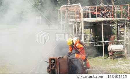 Firefighter fighting smoke flame use fire hose chemical water foam spray engine. Firefighter Rescue training in fire fighting extinguisher. Fireman wear hard hat safety suit uniform for protection 128405225