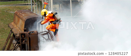 Firefighter Rescue training in fire fighting extinguisher. Firefighter fighting with flame using fire hose chemical water foam spray engine. Fireman wear hard hat, safety suit uniform for protection Firefighter Rescue training in fire fighting extinguisher. Firefighter fighting with flame using fire hose chemical water foam spray engine. Fireman wear hard hat, safety suit uniform for protection 128405227