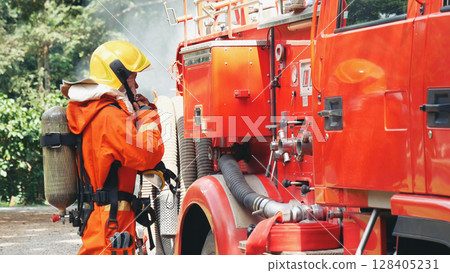 Fireman prepare equipment fighting extinguisher at fire engine truck. Firefighter fighting with smoke flame using fire hose, tube, chemical water foam spray at truck. Fireman wear hard hat protection 128405231