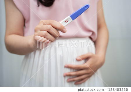 Asian holding pregnancy test for female of ovulation day, fetus, maternity, childbirth, birth control. 128405236