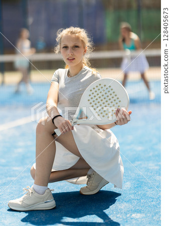 Woman sitting on court with racket 128405673