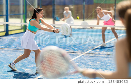 Woman playing with other paddle tennis players Woman playing with other paddle tennis players 128405683