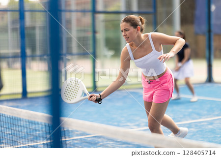 woman participates in a paddle tennis tournament 128405714