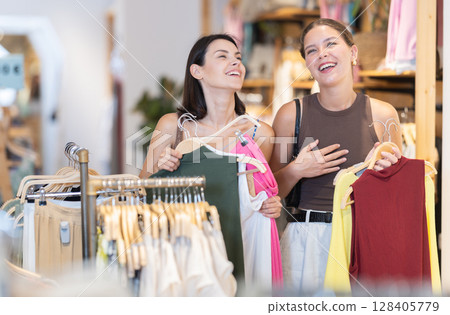 Two positive girls are buying crop top in store 128405779