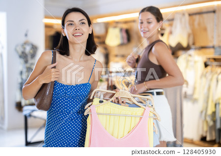 Two positive girls are buying crop top in store 128405930