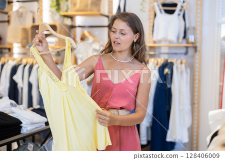Young woman tearing out a new dress Young woman tearing out a new dress 128406009
