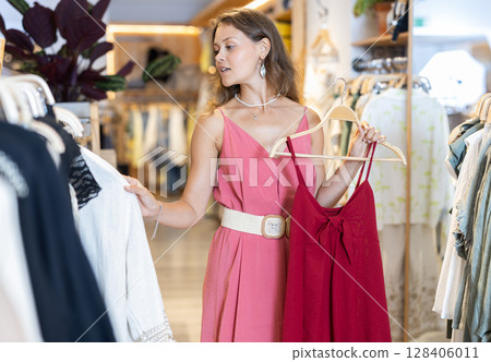 Girl chooses something in clothing store 128406011
