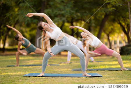 Yoga lesson visitors girls perform utkata konasana in park 128406029