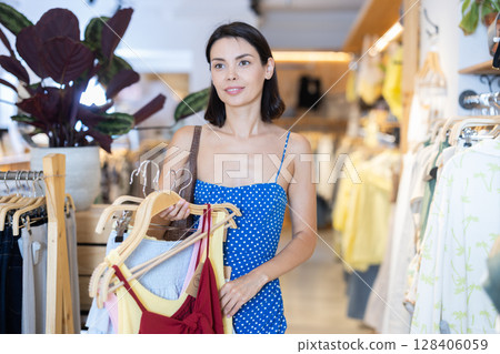 Young woman choosing clothes in a store in summer 128406059