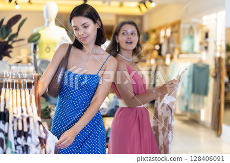 Two women standing in a boutique and choosing clothes 128406091