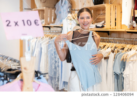 Young woman choosing clothes in a store in summer Young woman choosing clothes in a store in summer 128406094