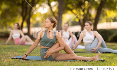 Group of young women doing yoga in park 128406195