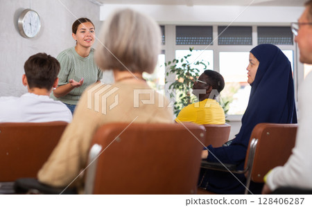 Young female tutor leading educational class for multiethnic group 128406287