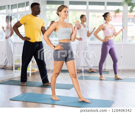 Girl exercising with figure eight band during group fitness class 128406342