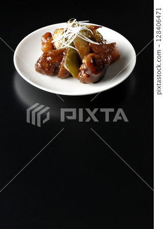 Sweet and sour pork with black vinegar photographed on a black background 128406471