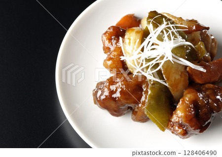 Sweet and sour pork with black vinegar photographed on a black background 128406490