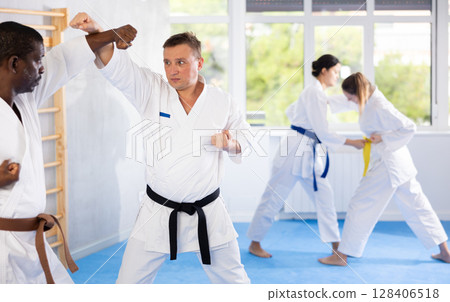 Two men practicing punches during karate classes in gym 128406518
